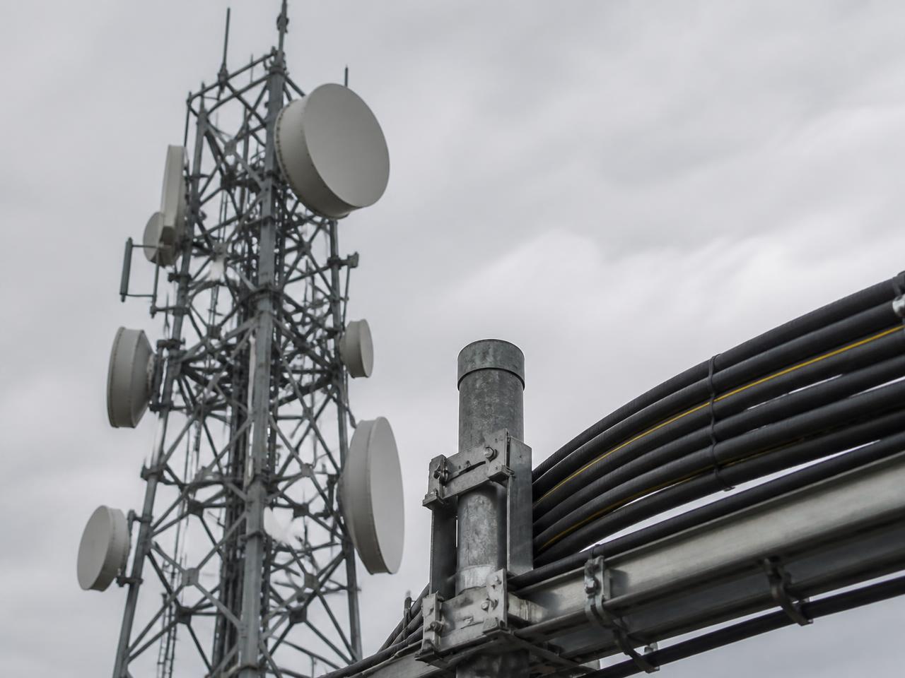 Telecommunications tower with microwave dishes and cable infrastructure